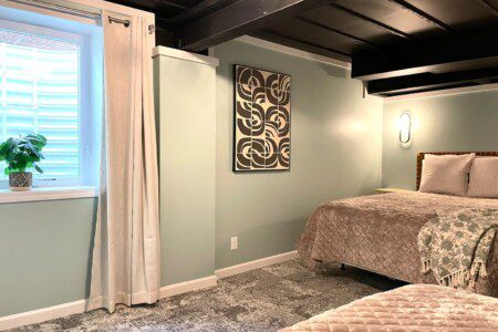 Basement Bedroom with two queen beds; nightstand a clocks w/ USB and outlets to make charging devices super convenient