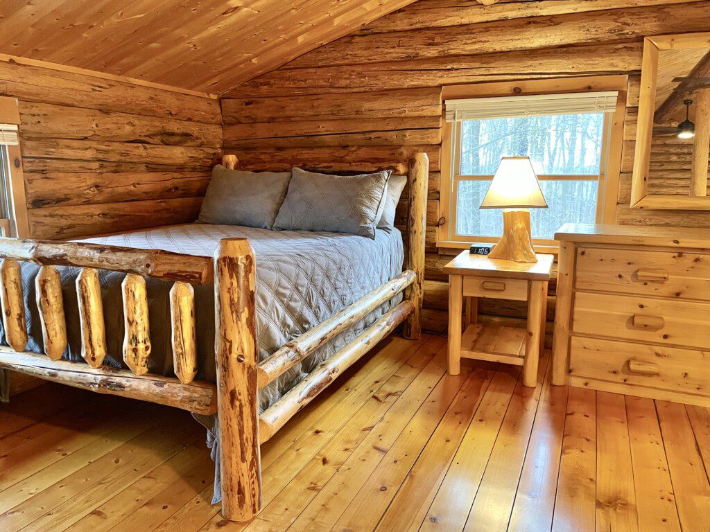 Bedroom #3: upstairs full sized bed with easy charging stations beside beds; open loft design - an airy, connected space overlooking the rest of the cabin, though not a private room.
