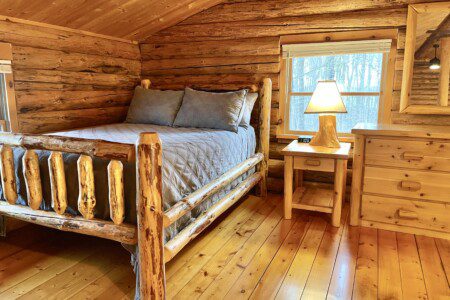Bedroom #3: upstairs full sized bed with easy charging stations beside beds; open loft design - an airy, connected space overlooking the rest of the cabin, though not a private room.