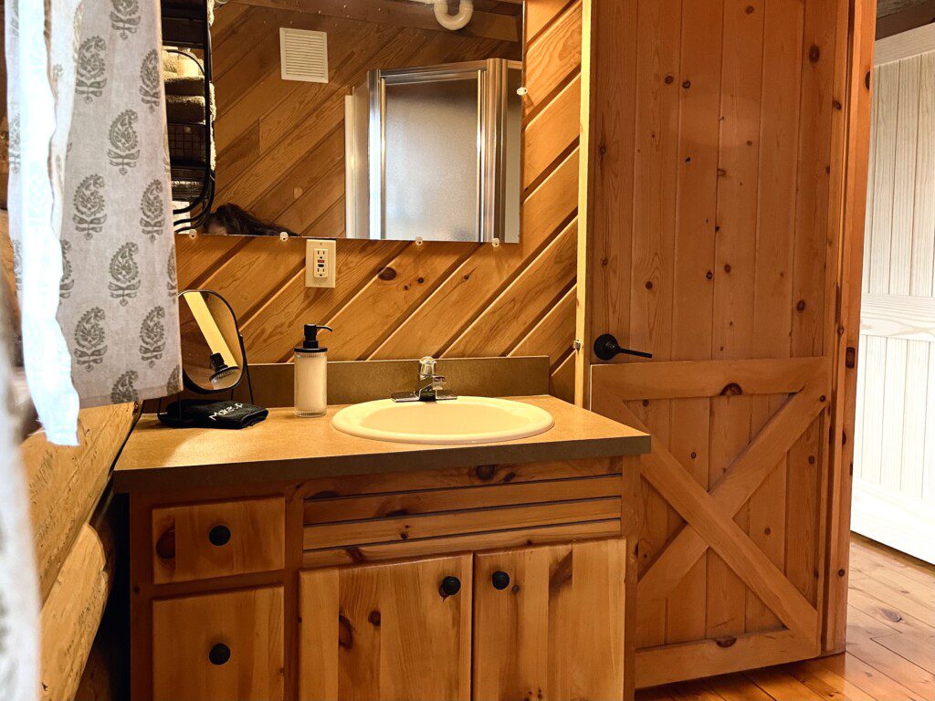 Bathroom #1: main floor bathroom with shower cabin furnished with towels, wash clothes, shampoo, and soap