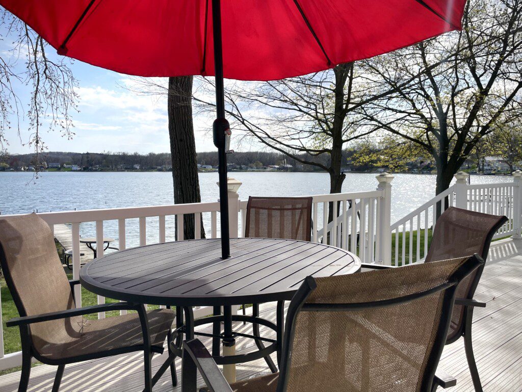 Relax under the umbrella on the back deck, perfect for meals or sipping drinks while soaking in the lake views.