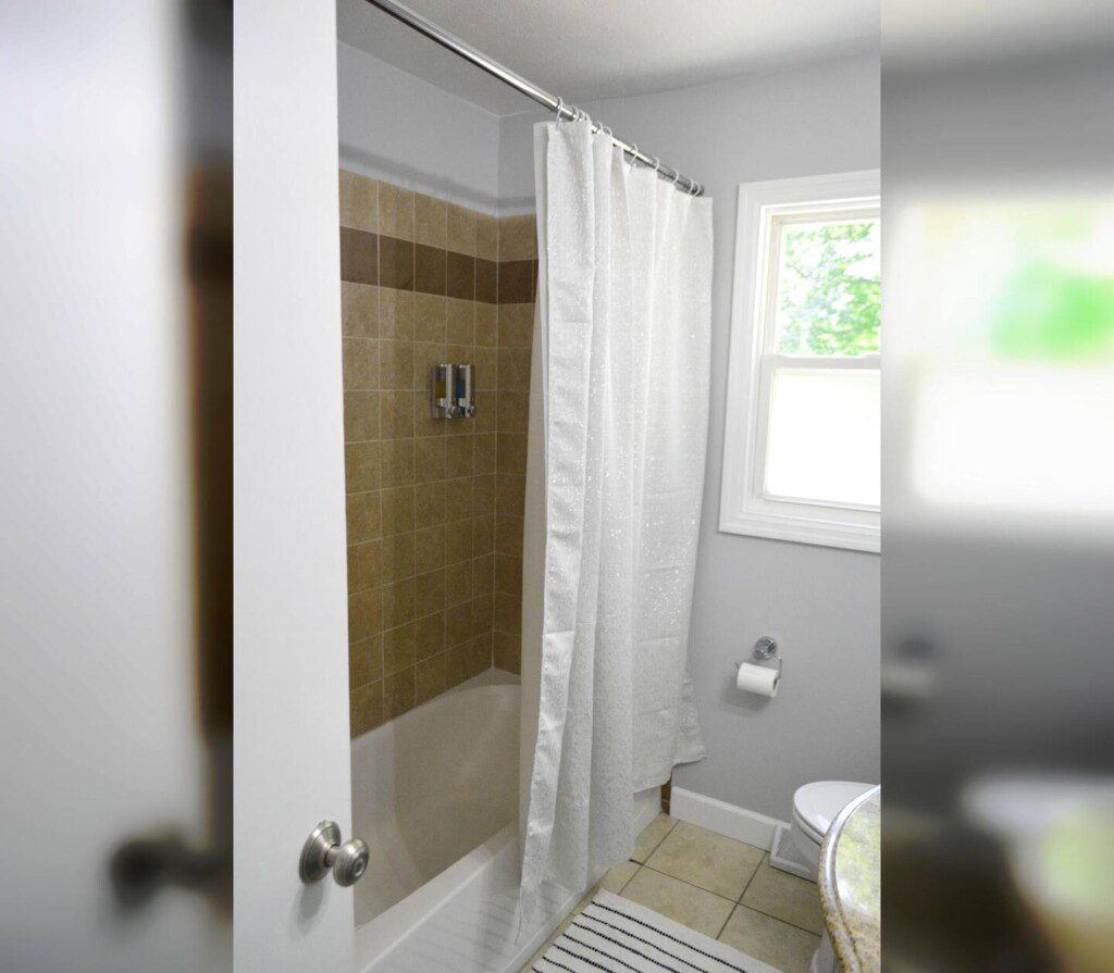 Hallway bathroom with tub and shower.