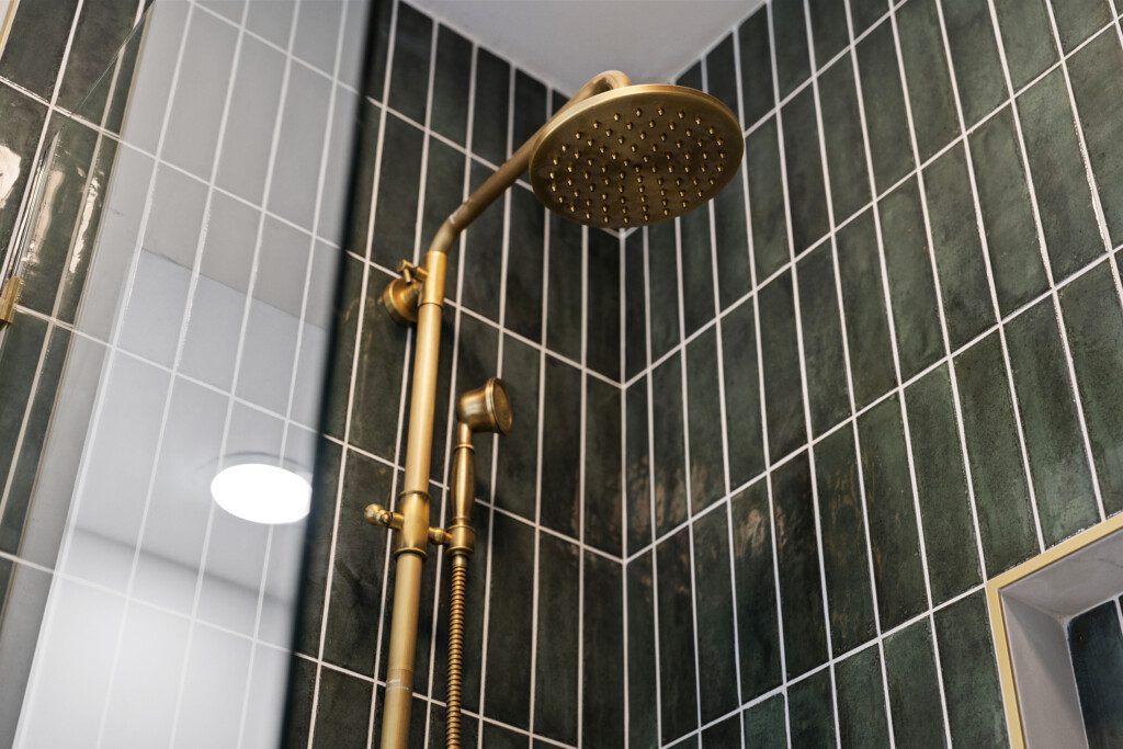 Bathroom 2 boasts a chic design with emerald tile + gold fixtures ✨ Enjoy the walk-in shower, modern vanity, and spa-like touches that make your stay feel luxurious.
