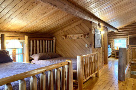 Bedroom #2: upstairs - two beds in room (one queen and one full) & easy charging stations beside beds; open loft design - an airy, connected space overlooking the rest of the cabin, though not a private room.