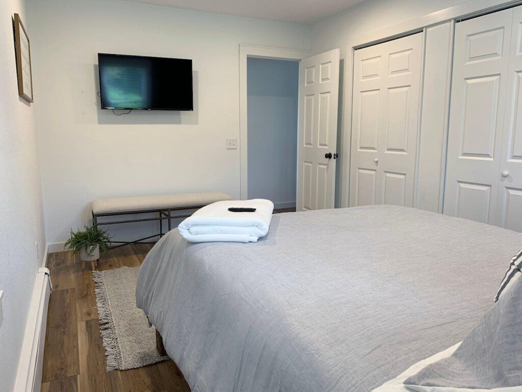 Bedroom #1 comfortable queen bed that has a 40" TCL Roku TV with complimentary YouTubeTV Access (cable-like TV); USB clock right beside the bed for all your charging needs