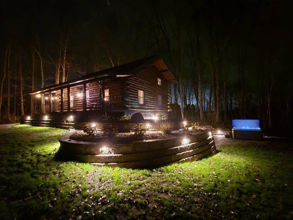Our log cabin under the lights! Enjoy the hot tub late into the evening under the lights!
