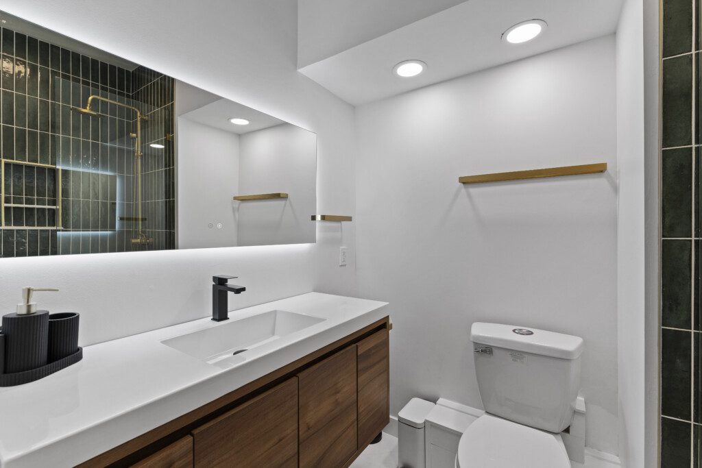 Bathroom 2 boasts a chic design with emerald tile + gold fixtures ✨ Enjoy the walk-in shower, modern vanity, and spa-like touches that make your stay feel luxurious.