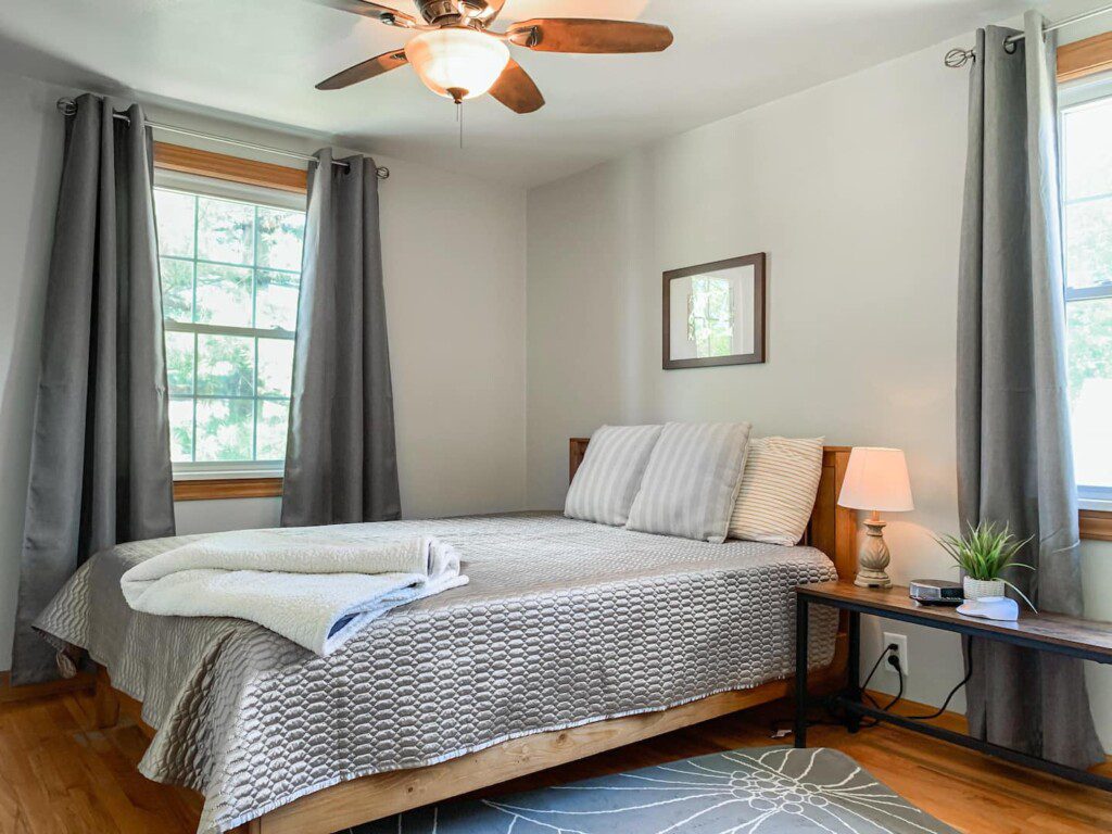 Bedroom #3 with highly rated Lucid queen mattress; 43 Inch Roku TV with YouTubeTV access; on nightstand a clock w/ USB and outlets to make charging devices super convenient