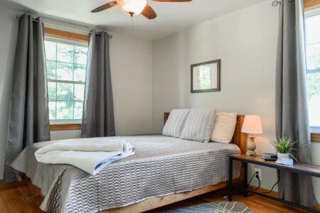 Bedroom #3 with highly rated Lucid queen mattress; 43 Inch Roku TV with YouTubeTV access; on nightstand a clock w/ USB and outlets to make charging devices super convenient