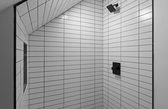 Bathroom 3 (Upstairs) – Modern full bath featuring a spacious walk-in shower with sleek tile, double vanity with backlit mirror, and stylish black fixtures.