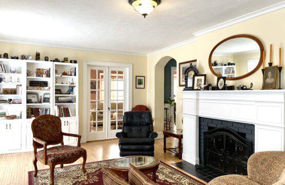 Curl up with a good book beside the fireplace in this charming sitting room 📚🔥 — built-in shelves, a classic arched doorway, and a plush chair create your perfect reading escape.