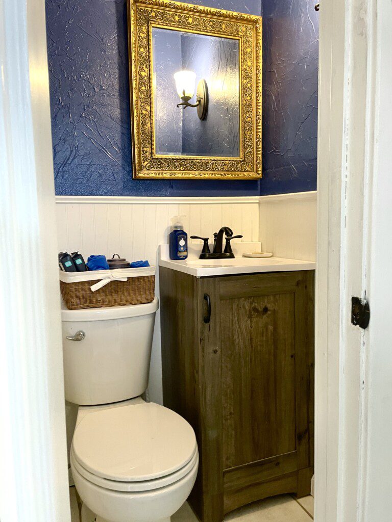 Your private spa experience awaits 🛁✨ — rich wood tones, gold accents, and cool navy walls create a sophisticated bathroom where you can unwind in style every single day of your stay.