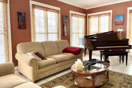 Your living room, your rules 🛋️🎶 — sink into the plush sofa, soak in the warm, golden light, and let the music of the grand piano set the tone for an unforgettable evening in.